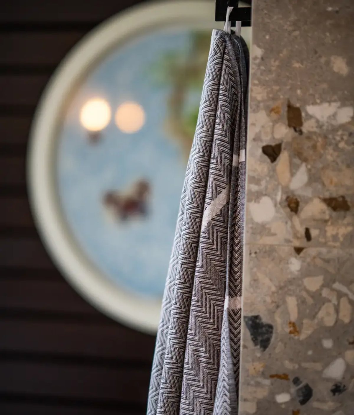 The image features a decorative towel hanging in a lodge room, with a blurred circular artwork in the background, enhancing the ambiance of Silvan Safari.